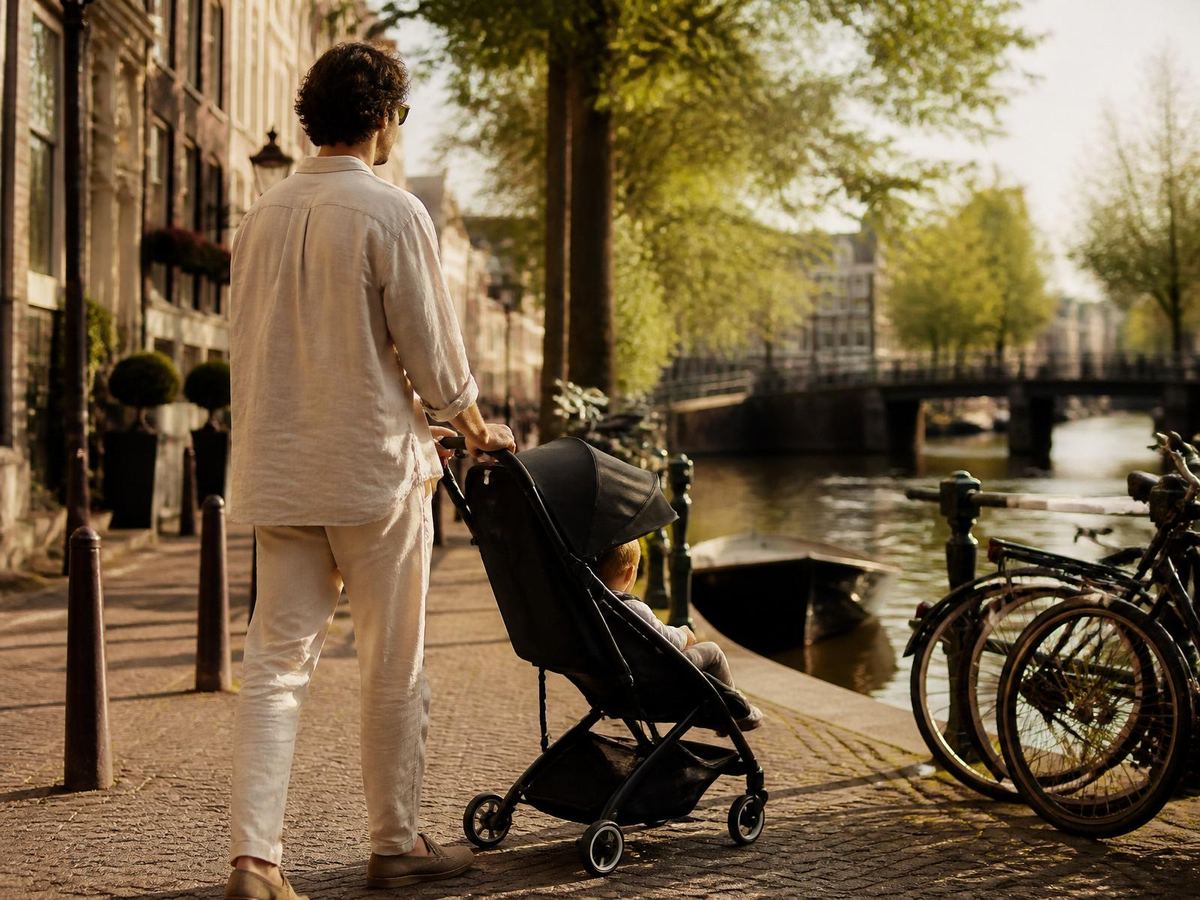Familia paseando con un cochecito por una calle de Ámsterdam